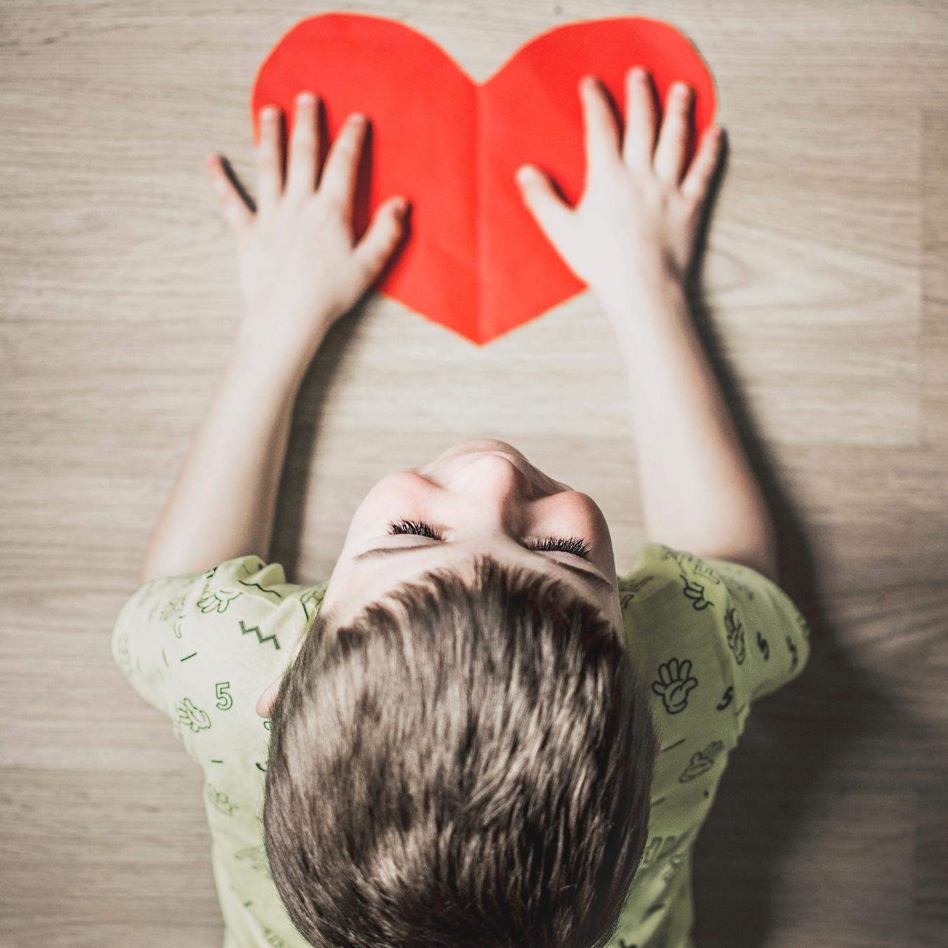 Kind mit Papierherz (Anna Kolosyuk - unsplash)